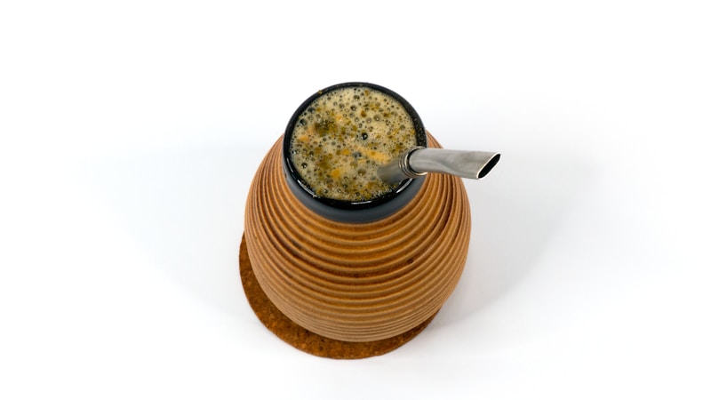 Brown and black ceramic mug with stainless steel spoon