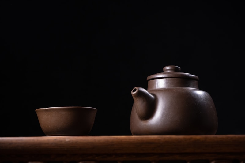 A tea pot and a cup on a table