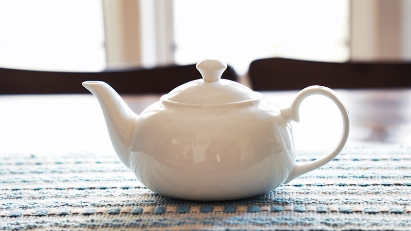 A white tea pot sitting on top of a table