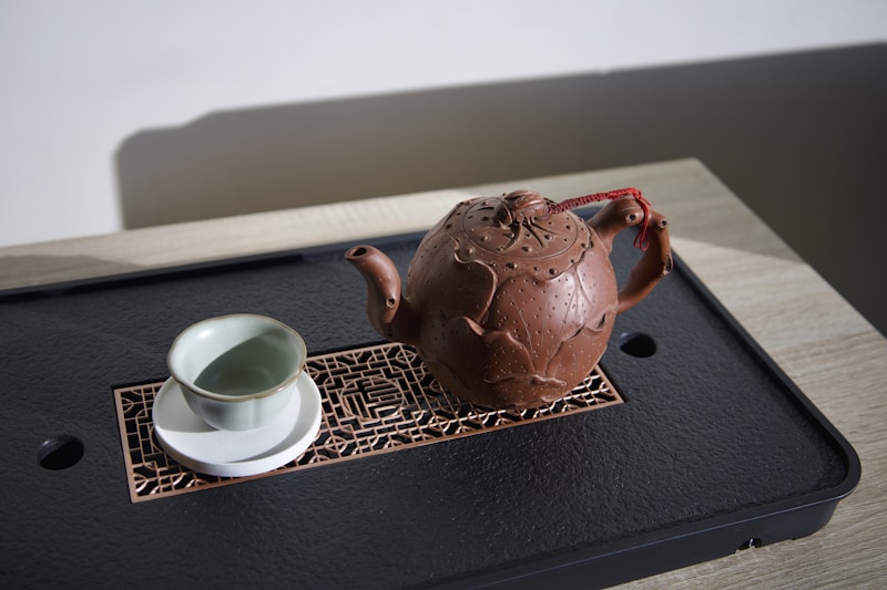 A tea pot and a cup on a tray
