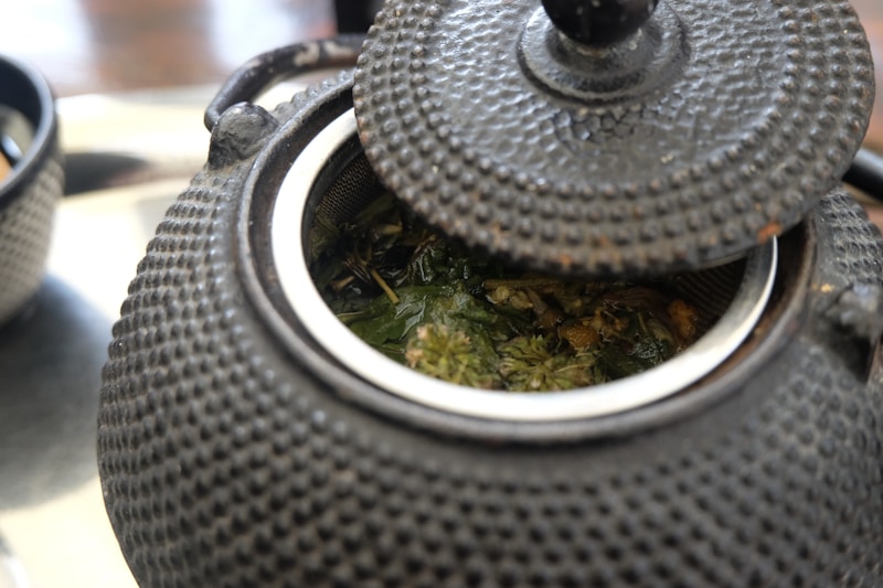 Close-up of a cast iron teapot with loose leaf tea