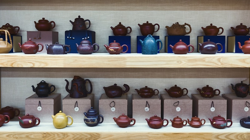 Collection of colorful teapots displayed on shelves
