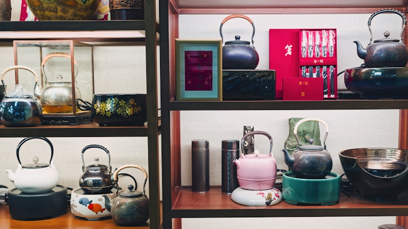 Collection of decorative teapots and tea sets on shelves